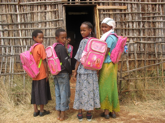 A group of children standing in front of a building

Description automatically generated