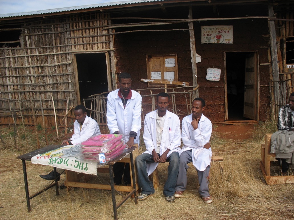 A group of men in white coats outside a building

Description automatically generated