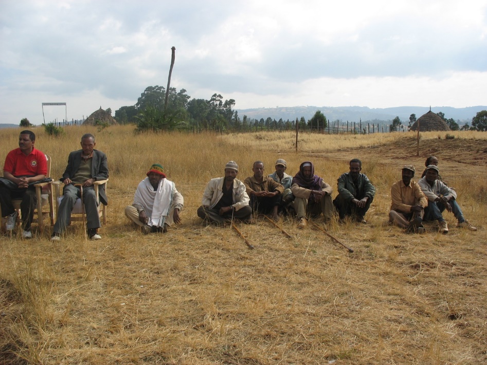 A group of men sitting in a field

Description automatically generated