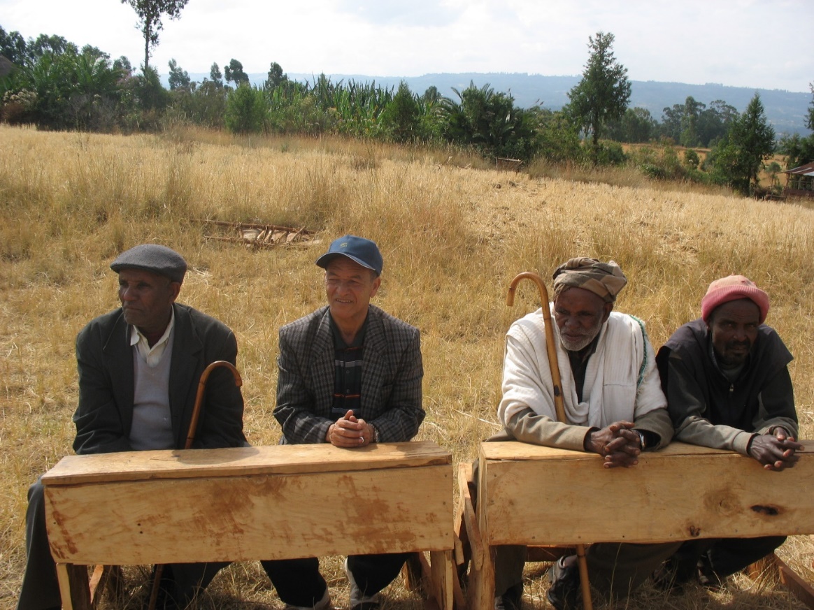 A group of men sitting on a bench

Description automatically generated