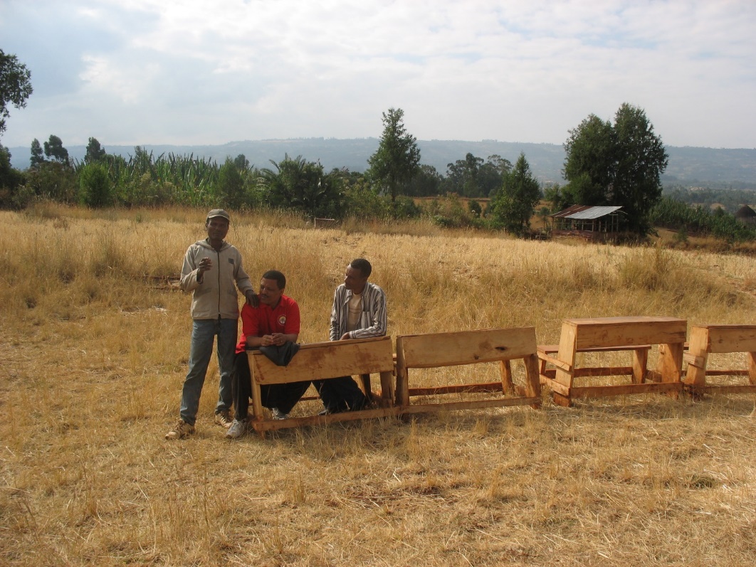 A group of men standing next to a row of benches

Description automatically generated