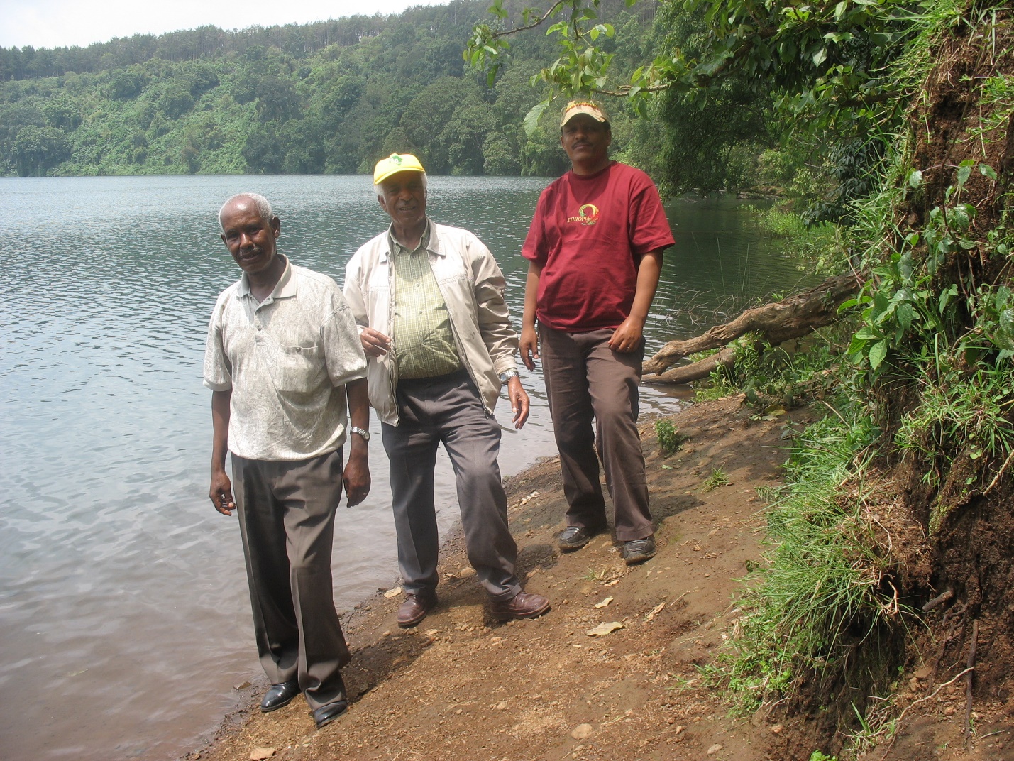 A group of men standing on a shore of a lake

Description automatically generated