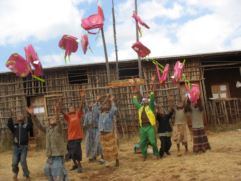 A group of people holding up bags

Description automatically generated