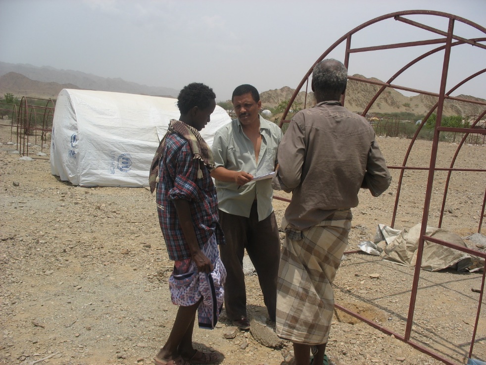 A group of people standing around a metal structure

Description automatically generated