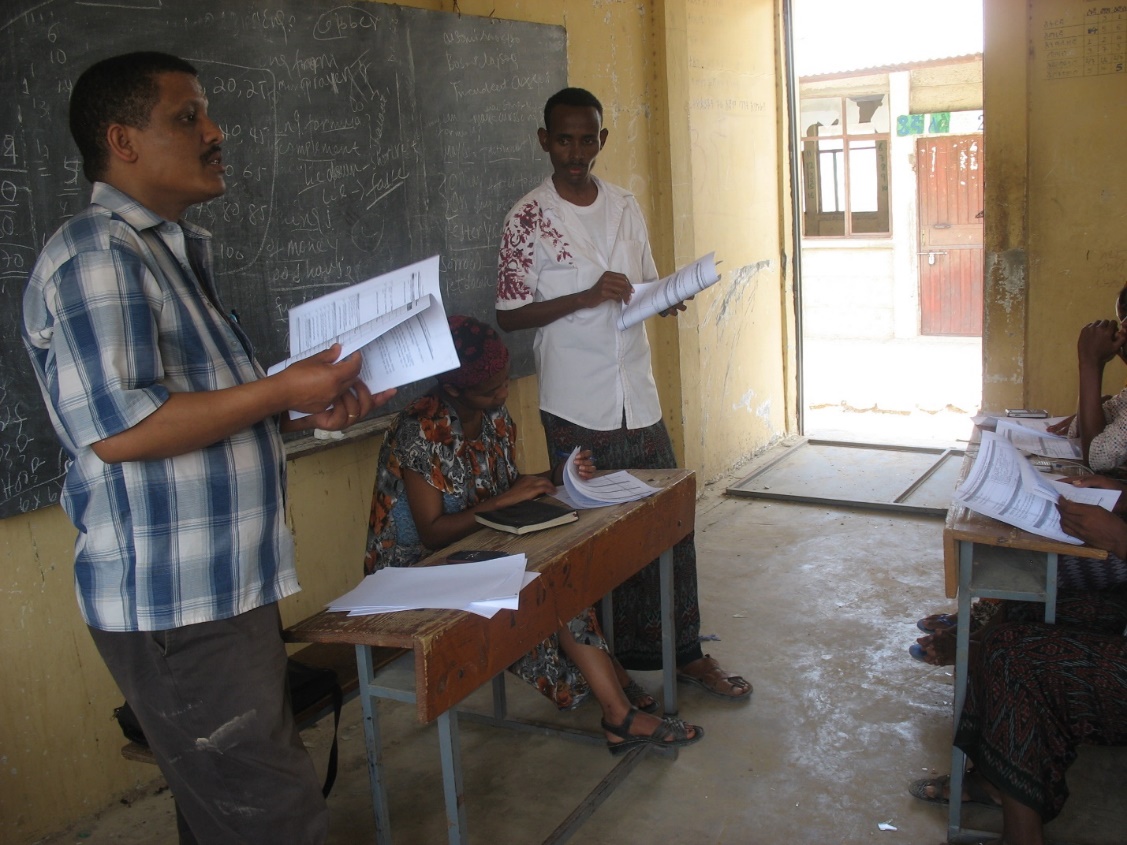 A group of people standing in a classroom

Description automatically generated